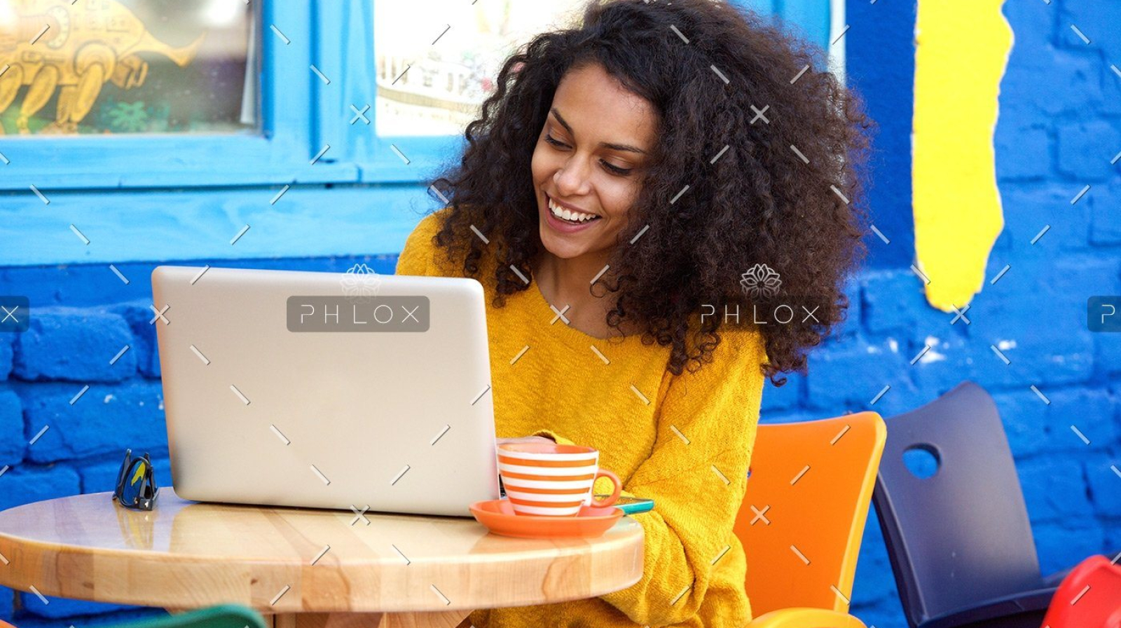 demo-attachment-29-happy-young-woman-sitting-at-outdoor-cafe-using-PFFBJ93
